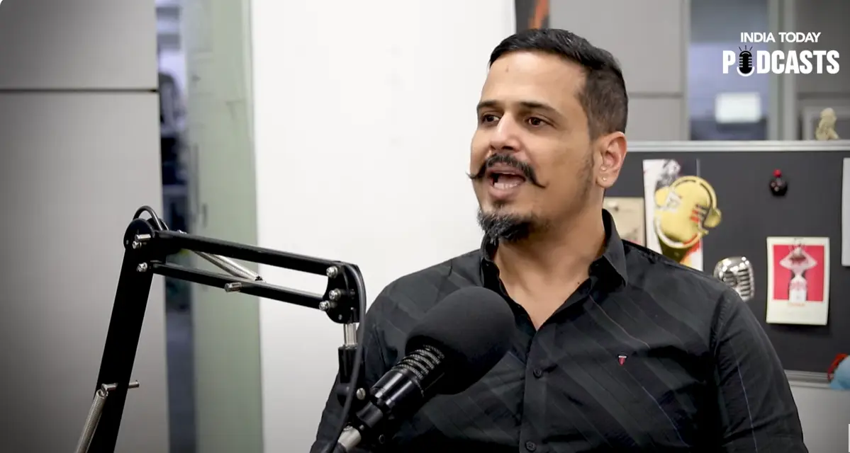 a man with a mustache speaking into a microphone